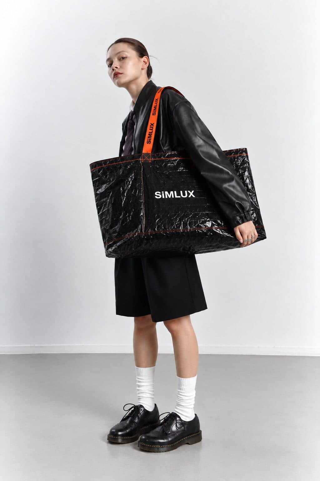 Model in a black leather jacket carrying a SiMLUX Cargo Bag