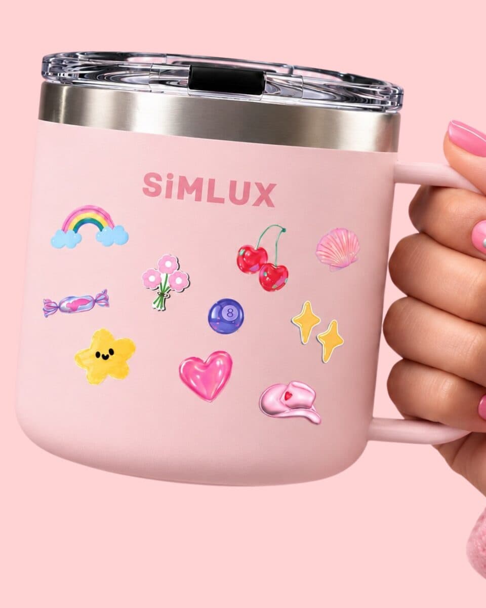 Hand with pink nails holding a Pink SiMLUX Mug decorated with stickers