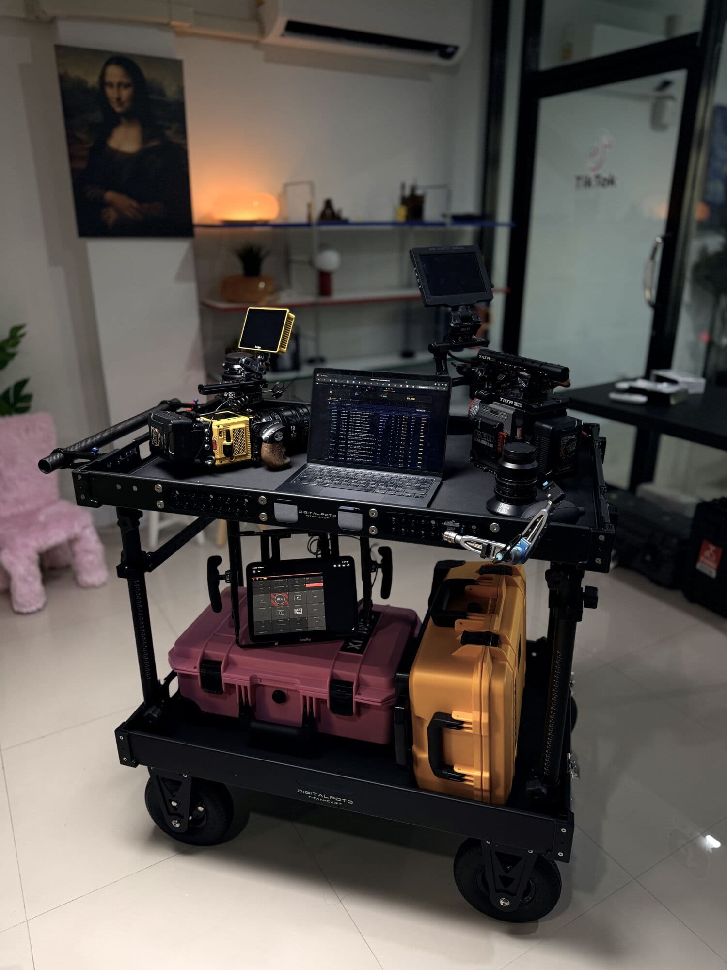 Camera cart in a studio carrying Pink and Yellow cases